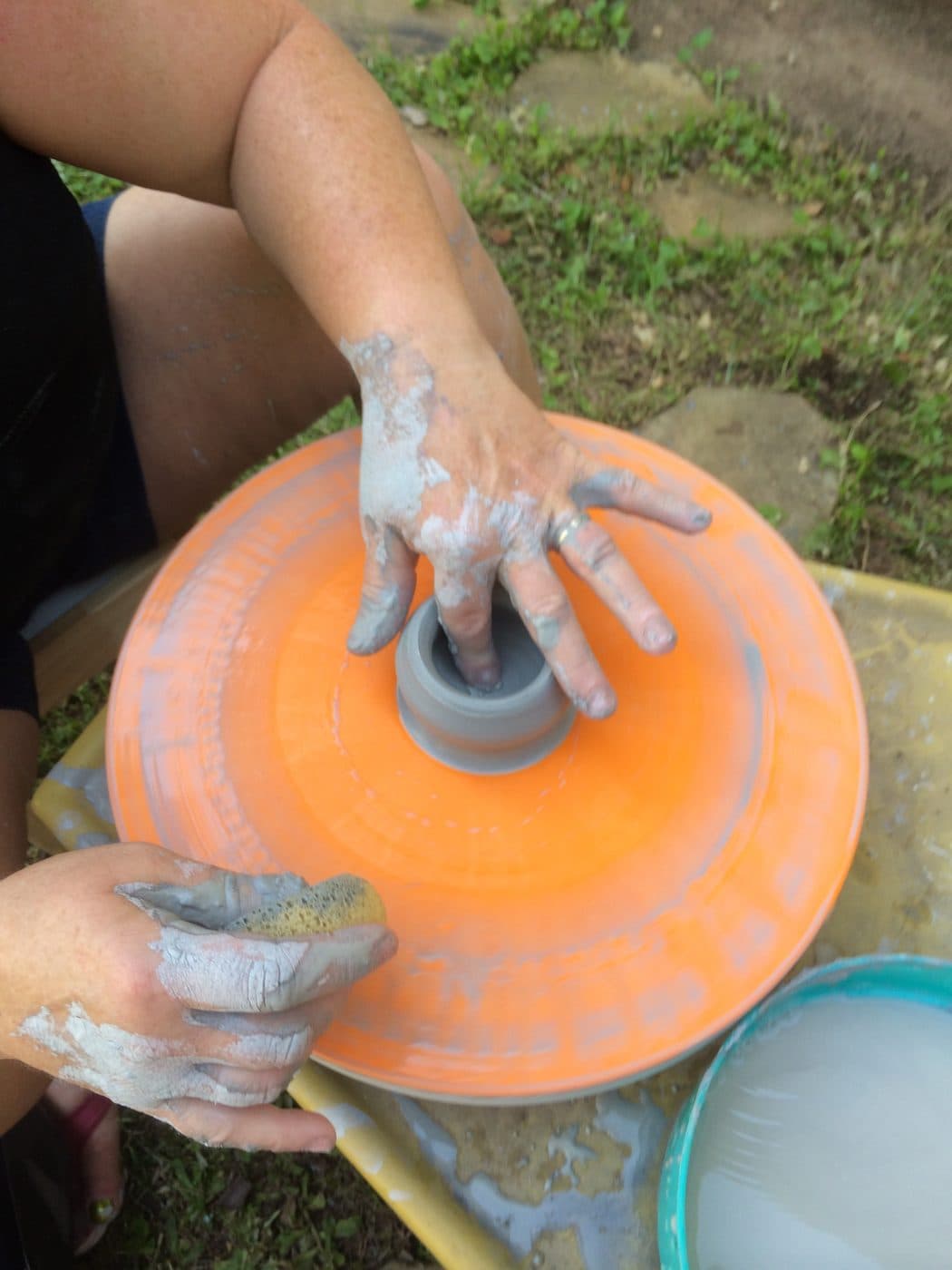 Small hands shaping clay on the pottery wheel